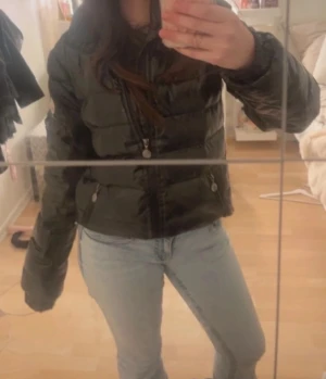 Svart pufferjacka med dragkedja - Säljer en svart, glansig pufferjacka. Den har ingen luva men är ganska varm och bra för vintern, lite defekter men ser bra ut. Pris kan diskuteras vill köpa en ny, så jag snabb säljer. Vet ej om den är äkta 