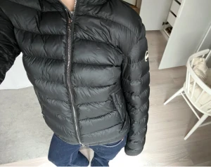 Svart dunjacka från Colmar  - Svart dunjacka från Colmar. Jackan har ett litet hål vid jackfickan, men är i övrigt i mycket bra skick. Hålet går att täcka med tejp. 