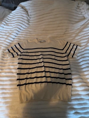 Randig kortärmad tröja från Zara - Säljer en vit och marinblå randig tröja från Zara i storlek M, skulle dock säga att den passar S. Tröjan har korta ärmar och klassisk rund halsringning. Perfekt för dig som gillar en stilren och tidlös look. Materialet känns väldigt mjukt och skönt mot huden.