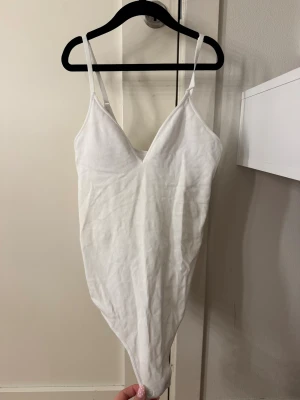 Vit body H&M - En vit body från H&M. Materialet är randigt, alltså inte slätt. Storlek S. Det är en liten sminkfäck vid bröstet som man ser på sista bilden men det är absolut inget man märker av eller tänker på. Använd 1 gång 