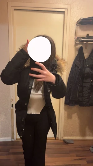 Svart hollies jacka med äkta päls - Säljer en svart hollies jacka med snygg äkta päls runt huvan. Jackan har knappar och dragkedja framtill, samt en längre modell som håller dig varm under kalla dagar. Perfekt för dig som vill ha en stilren och praktisk vinterjacka som värmer jättebra och är väldigt varm. Köpt för 6500kr, är i storleksklass xs/s