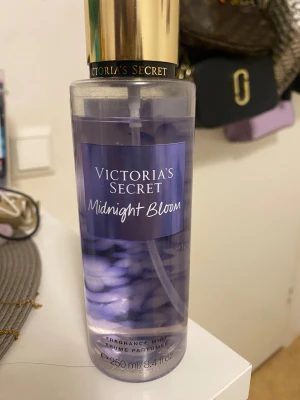 Victoria's Secret Midnight Bloom Mist - Fragrance mist med 250 ml volym. Midnight Bloom bjuder på en mix av moon flower och creamy woods. Perfekt för dig som vill ha en unik och fräsch doft med en touch av mystik.