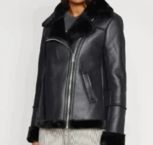 Svart skinnjacka med fuskpäls - Säljer en svart skinnjacka med bred krage och fuskpälsdetaljer. Jackan har en schysst asymmetrisk dragkedja, två fickor och mjukt foder. Perfekt för dig som vill ha en edgy look med extra värme under kalla dagar.