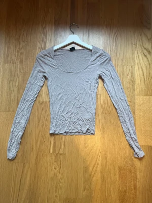 Beige långärmad  - Säljer den här långärmade tröjan med slits längst ner vid ärmarna då den inte kommer till användning längre 
