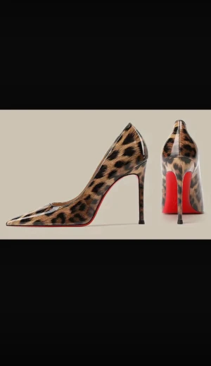 Nya Leopardmönstrade pumps med röd sula  - Snygga pumps med leopardmönster och glansig finish Skorna har spetsig tå, hög klack och den ikoniska röda sulan. Perfekt för dig som vill sticka ut med ett djärvt och trendigt statement. Materialet är syntet med skinnkänsla. 9cm klack