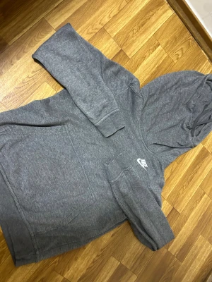 Grå Nike hoodie med huva - Säljer min gråa Nike hoodie – superfräsch & knappt använd!  Köptes för 1800 kr och säljs nu för 800 kr. Hoodien är i toppskick, helt utan fläckar eller noppor. Jag har haft den i ungefär ett år men bara använt den 2 gånger, så den är i princip som ny.  ✔️ Äkta Nike ✔️ Perfekt grå färg som passar till allt ✔️ Mjuk, bekväm och håller formen ✔️ Jättefräsch och välvårdad  Perfekt för dig som vill ha en kvalitets-hoodie till ett riktigt bra pris!