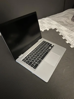 ASUS Chromebook - Snygg och lätt ASUS Chromebook i silver. Utrustad med bekväm tangentbordslayout och stor touchpad. Skärmen ser ut att vara i gott skick, och chassit har endast mindre ytliga märken. Perfekt för studier, surf och arbete. Batteritid och prestanda för vardagsbruk.