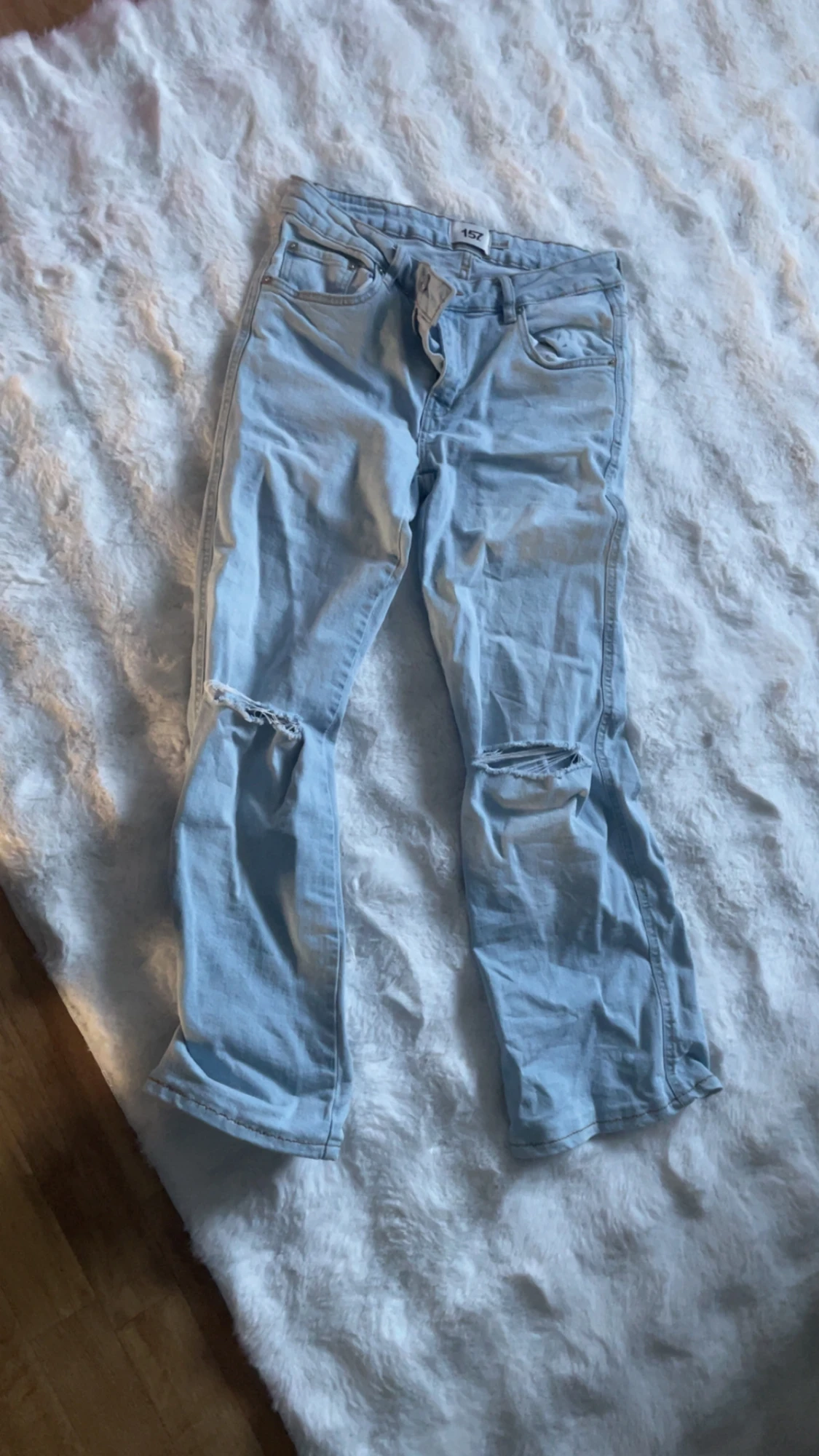 Ljusblå jeans med hål vid knäna - 1