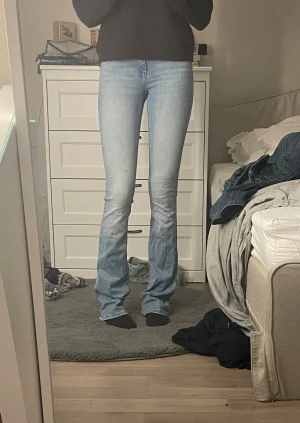 Bootcut jeans i ljusblå denim från ONLY - Säljer ett par ljusblå bootcut jeans från ONLY i storlek XS längd 38. Jeansen har klassisk femficksdesign, dragkedja och knapp framtill. Snyggt bootcut-snitt med lite utsvängda ben och hög midja. Perfekt för dig som gillar en retro vibe och ljus denim.jag är 177 och de är LÅNGA på mig