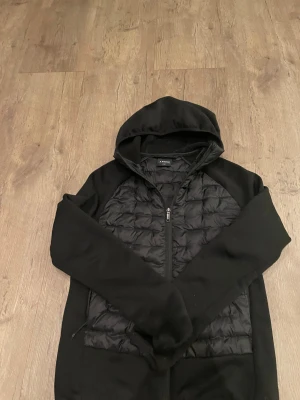 Svart cardigan jacka med huva från Everest - Svart cardigan jacka från Everest i storlek 38. En skön cardigan som är inte så mycket använd. Mitt pris är 220 kr. Kom med prisförslag!