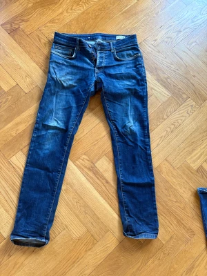 Blå jeans från Pour Homme, 30/32 - Snygga blå jeans från Pour Homme i klassisk tvätt med lätt slitning. Modellen har smal passform och raka ben. Tillverkade i 98% bomull och 2% lycra för extra stretch och komfort. Perfekta för dig som gillar en stilren och enkel look.