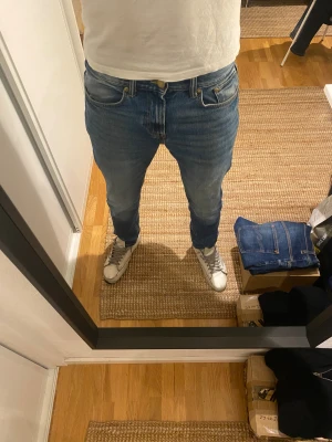 Denim &s blå jeans  - Säljer ett par Denim &s jeans i klassisk blå tvätt med snygga slitningar. Modellen har rak passform, fem fickor och knappgylf. Jeansen är tillverkade i mjukt bomullsjeansmaterial och har en normal midja. Jeansen är endast använda ett fåtal gånger, därav mycket fint skick! Tveka inte att höra av er om ni har frågor eller prisförslag!
