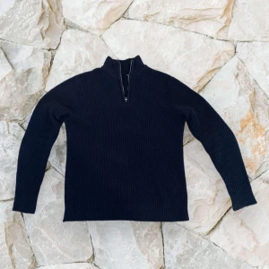Mörkblå stickad half zip-tröja  - Mörkblå stickad tröja från lager 157 i storlek S. Tröjan har en ribbad struktur, hög krage och en snygg half zip-dragkedja framtill. Perfekt för kyliga dagar och enkel att styla med jeans eller cargobyxor. 