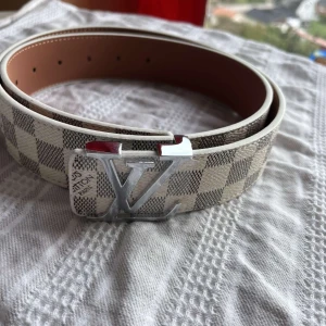 L-bälte  - Snyggt L-bälte i Damier-mönster med silver spänne. Aldrig använt, Storlek: 110 cm
