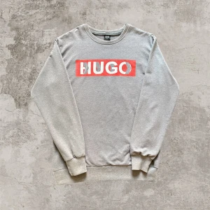 Grå sweatshirt från Hugo Boss - Stilren Hugo boss tröja i storlek M, mycket bra skick andvänd några gånger. Inga defekter. Måtten är 45 axelbredd X 68cm