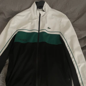 Lacoste Zip hoodie - Använd ett fåtal gånger. Väldigt bra skick. Köpt för cirka 2000 Kr. Storleken är L men passar mellan M/L