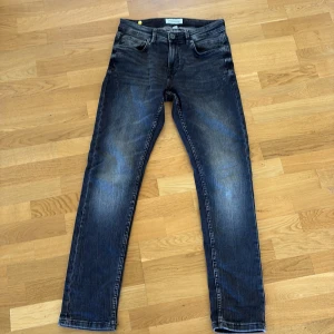Svarta jeans från Smog Original 29/32 - Svarta jeans från Smog Original i storlek 29/32. Jeansen har en klassisk femficksdesign, raka/smala ben och slitningar framtill. Mjuka och sköna. Inga tecken på användning. 