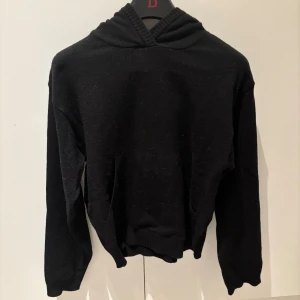 Svart stickad hoodie från BikBok XS - Svart stickad hoodie från BikBok i storlek XS. Tröjan har en klassisk huva, ribbade muddar och är långärmad. Perfekt för dig som gillar en enkel och stilren look. Materialet känns mjukt och passar bra till allt. Använd endast en gång.