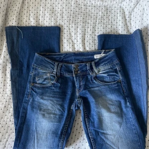 Lowwaist jeans - Jeans som är väldigt lowwaist och sydda bootcut. Lite stretchiga i tyget. Midjemått: 39,5 cm Innerbenslängd: 80 cm