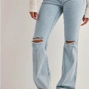 Ljusblå jeans med slitningar  - Säljer nu mina jeans från Nelly l storlek 32. De är ljusblå med hål i knäna och rosa detaljer på fickorna, mycket bra skick!!!Skriv om ni är intresserade eller vill ha fler bilder så fixar jag det💕💕Priset kan diskuteras! Orginal pris (699kr)