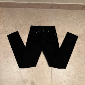 Svarta jeans från Nudie Jeans, 25/32 - Snygga svarta jeans från Nudie jeans. Perfekta inför vintern och passar folk som är 150-170. Helt nytt skick (inga slitningar) skriv gärna vid frågor
