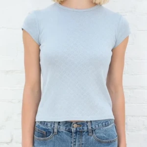 Ljusblå ribbad topp med hjärtmönster - Supersöt ljusblå topp från Brandy Melville med invävt hjärtmönster över hela tyget. Perfekt att styla med jeans eller kjol. 