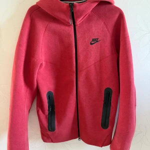 Röd Nike Tech Fleece - Säljer min lillebrors röda nike tech fleece som är i storlek XS då han växt ur den. Den är i mycket bra skick med mindre skavanker. Jag kan skicka fler bilder om det begärs. Kontakta mig om du har frågor eller undrar över något, priset kan diskuteras.