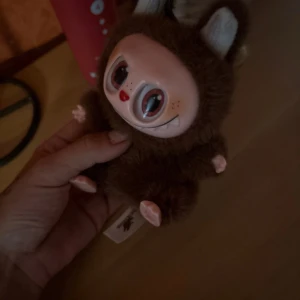 Labubu  - Ingen bok syns på bilderna, endast en leksak med päls och stora ögon. Om du söker böcker, vänligen ladda upp en bild där boken är tydligt synlig. Labubu 