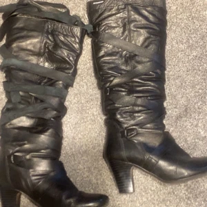 Svarta höga boots med snörning - Vintage boots – strl 37 Säljer ett par vintage boots i storlek 37. De är i fint skick, har snörning framtill och en lite spetsigare tå. Bekväma att gå i och passar till mycket.