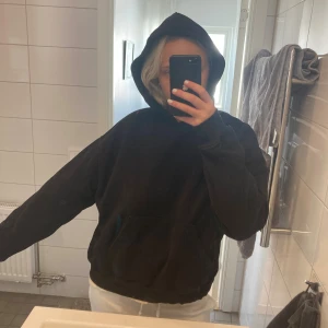 Svart hoodie från Gina Tricot - En svart hoodie från Gina Tricot, basically basics-kollektionen. Oversized passform med stor huva och magficka. Perfekt för chill dagar och enkel att matcha med allt. Mjuk insida och klassisk look.