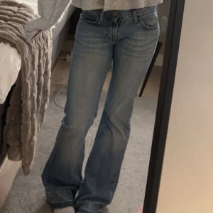 Bootcut jeans från Fornarina - Säljer ett par ljusblå bootcut jeans från Fornarina med slitna detaljer och råa kanter nertill.  låg midja och snygga kontrastsömmar på bakfickorna. 💞