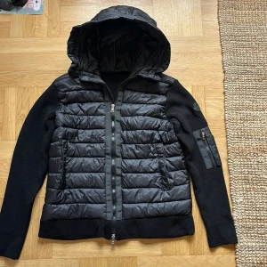Svart Moncler pufferjacka med huva - Säljer min Moncler cardigan i strl 46-48. Den är ny men tyvärr för liten/fel storlek för mig. Riktigt snygg, klassisk Moncler som funkar året runt – både stilren och skön. Pris ej hugget i sten.