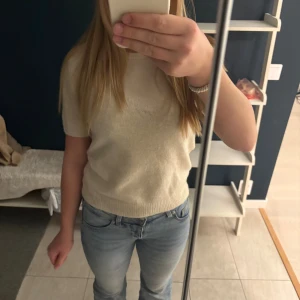 Beige stickad kortärmad tröja från hm - Säljer en supermjuk beige stickad tröja med korta ärmar och rund hals. Tröjan har en enkel och clean look med ribbade kanter vid ärmslut. Väldigt bra skick, har endast använt typ två gånger💕 pris går att diskutera 