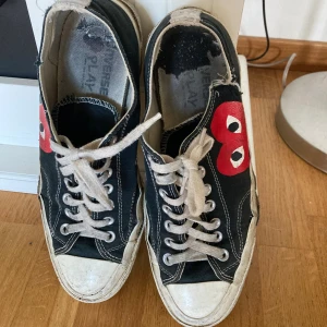Converse x Comme des Garçons Play sneakers - Svarta Converse x Comme des Garçons Play sneakers med den ikoniska röda hjärtloggan på sidan. Tillverkade i canvas för en klassisk streetstyle-look. Väldigt mycket slitna (se bilder) men går fortfarande att använda. Kan mötas i centrala- eller norra Stockholm för inbetalning och överlämning. 