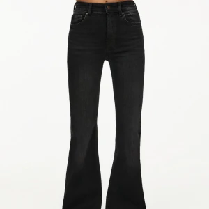 Svarta bootcut jeans med medel midja - Snygga svarta jeans med bootcut-modell och medel midja. Jeansen har klassisk femficksdesign, knapp och dragkedja framtill samt raka ben som blir utsvängda nedtill. Perfekta för dig som gillar en tidlös och trendig look.