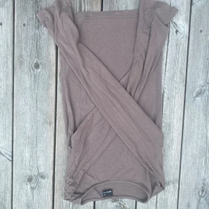 Brun långärmad topp från Gina Tricot - En basic brun långärmad topp från Gina Tricot i mjuk bomull. Modellen är enkel och tight med rund halsringning och smala ärmar. Perfekt att styla med jeans eller kjol för en clean look.