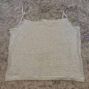 Randig linnetopp från 157, S - Säljer en tunn och skön randig linnetopp från 157 i storlek S. Toppen har smala axelband och är i svartvitt med täta ränder. Perfekt för varma dagar eller att styla lager på lager. Materialet känns mjukt och följsamt.