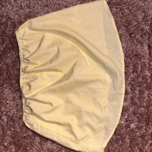 Gul och vit randig kortkjol - Söt kortkjol med tunna gula och vita ränder och resår i midjan. Perfekt för dig som gillar en enkel och fräsch stil. Lätt och luftig känsla, passar perfekt till varma dagar.