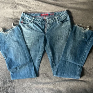 Blå jeans från Miss Sixty - Supersnygga lågmidjade utsvängda jeans från miss sixty med dragkedja. Bra skick förutom lite slitna längst ned. Skulle säga S/M. Midjemått:39 cm Innerbenslängd: 81 cm