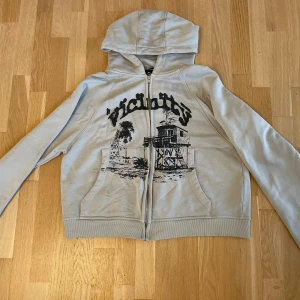 Ljusgrå hoodie med tryck från Vicinity - Ljusgrå hoodie från Vicinity med svart tryck. Använd 2 gånger original förpackning finns.
