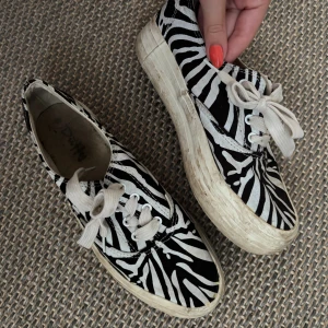 Zebramönstrade sneakers - Coola sneakers från Duffy med svartvitt zebramönster. Väl använda men har inte försökt göra rent dem, det mesta går nog bort med någon typ av rengöring. I strl 39 men passar en 38 också då de är lite små i strl