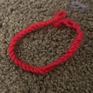 Handgjort mörkrosa garnarmband - Ett enkelt och charmigt armband i mörkrosa garn, handgjort med flätad design, Perfekt för dig som gillar unika accessoarer med personlig touch.