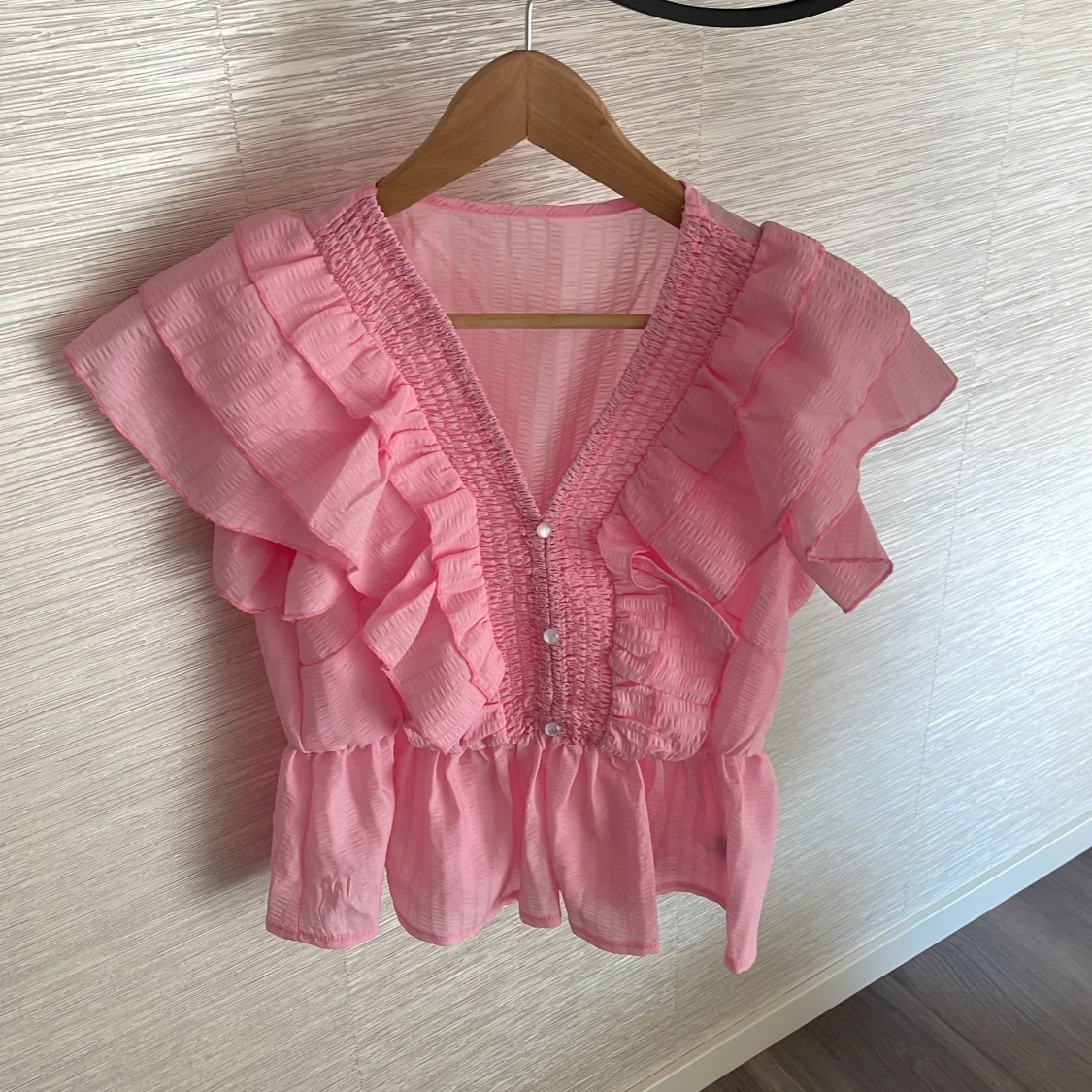 Rosa blus med volanger och v-ringning