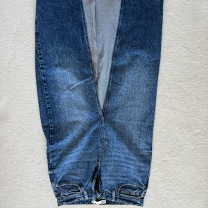 Blå jeans från ZARA med raka ben - Snygga blå jeans från ZARA med klassisk femficksdesign och raka ben. Jeansen har dragkedja och knapp framtill samt bälteshällor. Tillverkade i slitstarkt denimtyg med en lätt tvättad look och kontrastsömmar.