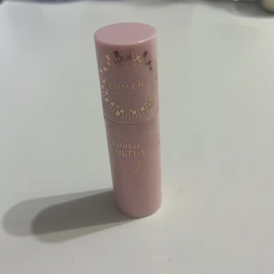 Lumene Natural Glow Multi-Stick Soft Glow - Krämig multi-stick från Lumene i färgen Soft Glow. Kommer i en söt ljusrosa hylsa med guldtext. Färgen är en mjuk, naturlig rosa-brun ton som passar perfekt som rouge, highlighter eller läppfärg. Vegansk formula och smidig att ta med i väskan. Är inte så pigmenterad 