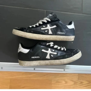 Svarta Premiatas - Jag säljer ett par riktigt feta svarta sneakers från Premiata med vita detaljer och logga på sidan🤩. Skorna har blivit reparerade vid hälen och är i ett hyfsat skick. Pris går att diskuteras, och är även öppen för byten🤝