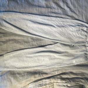 Grå nike mjukisbyxor - Snygga grå mjukisbyxor från Nike i storlek S. Byxorna har elastisk midja med snörning och broderad Nike-logga på benet. Tillverkade i mjukt bomullsmaterial för maximal komfort. Perfekta för chill eller träning. Använda fåtal gånger men färgen på snörningen har börjat gå av lite, se bild 5🤍