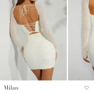 Vit pärlprydd kort klänning Milan - Superfin vit kort klänning med pärlprydda detaljer och transparenta långärmade ärmar. Klänningen har snörning i ryggen och en figurnär passform. Perfekt för dig som vill sticka ut med en elegant och trendig look. Dessutom aldrig använd!! Nypris 1155 kr! 