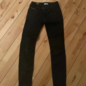 Svarta jeans Tommy Hilfiger - Svarta jeans från Tommy Hilfiger Denim med klassisk femficksdesign och diskret logga på bakfickan. Jeansen har en normal midja och är tillverkade i stretchig bomullsdenim för en bekväm känsla. Perfekta till sneakers eller boots.
