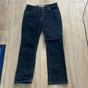 Mörkblå regular jeans från Denim - Snygga mörkblå jeans från Denim med regular fit. Klassisk femficksmodell med kontrastsömmar och raka ben. Jeansen har normalhög midja och är tillverkade i robust denimtyg som ger en tidlös look.